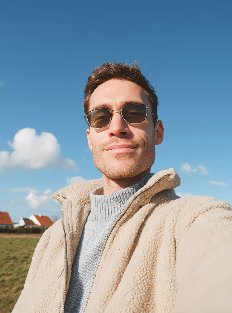 Portrait of a smiling man outdoors against a blue sky