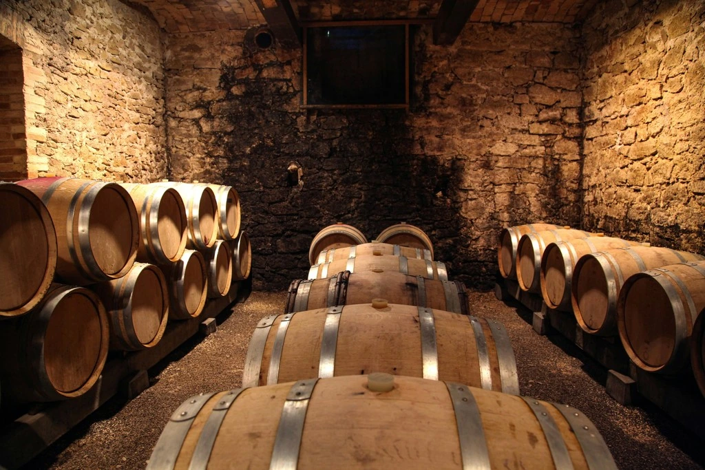 Brown wooden barrels against a brick wall